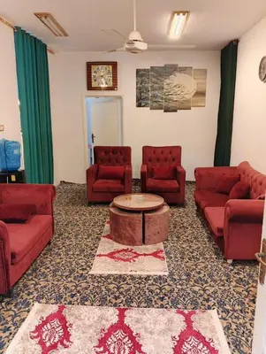 a living room with red couches and a coffee table at دار الخير للشقق المفروشة in Al Mafraq