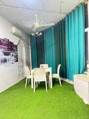 a dining room with a table and chairs and green carpet at دار الخير للشقق المفروشة in Al Mafraq