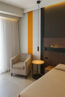 a room with a bed and a chair and a table at Crystal Collection Hotel in Amman