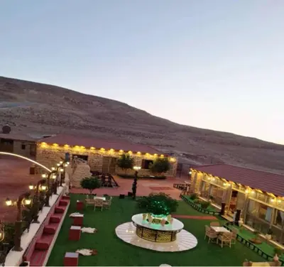 a courtyard with tables and chairs and lights at The modern village in ‘Ayn Amūn