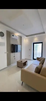 a bedroom with a bed and a couch and a tv at 2 bedroom studio - Fully furnished in Irbid