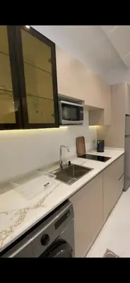 a white kitchen with a sink and a microwave at 2 bedroom studio - Fully furnished in Irbid