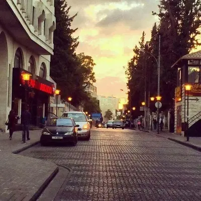 a city street with cars parked on a cobblestone road at Rainbow Street Studio Cozy Central in Amman