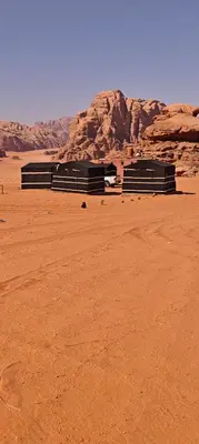 a group of black benches in the desert at Bedouin Horizons in Wadi Rum