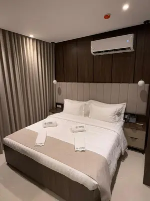 a bedroom with a large bed with two price tags on it at AL Hyatt Relax Hotel in Aqaba
