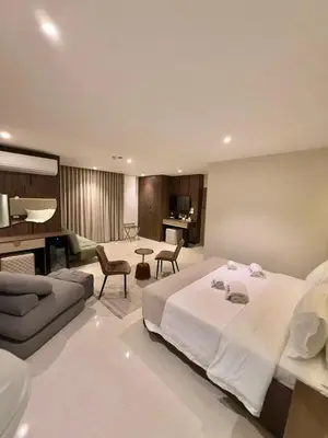 a bedroom with a large bed and a living room at AL Hyatt Relax Hotel in Aqaba