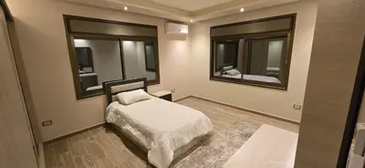 a small bedroom with a bed and two mirrors at Irbid irbid alrazi st in Irbid