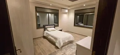 a bedroom with a bed and two mirrors at Irbid irbid alrazi st in Irbid