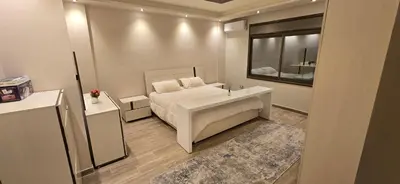 a bedroom with a white bed and a mirror at Irbid irbid alrazi st in Irbid