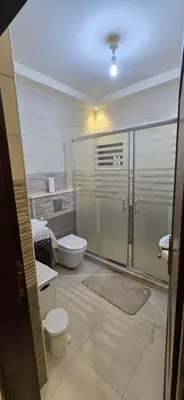 a bathroom with a toilet and a glass shower stall at Irbid irbid alrazi st in Irbid