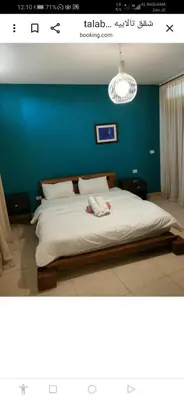 a bedroom with a large bed with a blue wall at jordanseatoursCom in Aqaba