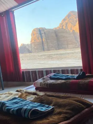 two beds in a room with a view of the desert at Kingdom of the Stars, Wadi Rum in Aqaba