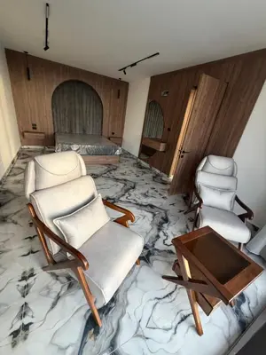 a room with a marble floor with chairs and a table at Alma chalets in Aş Şarīḩ