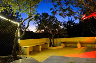 two benches sitting next to a fence at night at Sultan Chalet Ajloun شاليه السلطان in Ajloun