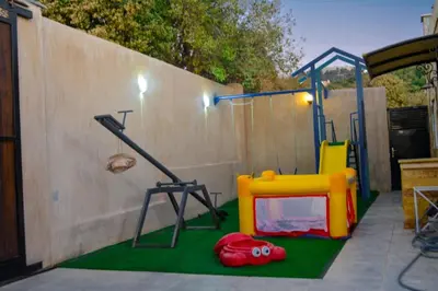 a playground with a play equipment in front of a fence at Sultan Chalet Ajloun شاليه السلطان in Ajloun