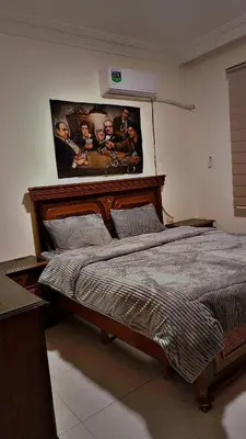 a bedroom with a bed with a poster on the wall at شقه مفروشه للإيجار مكونه من 4 غرف في عمان in Amman
