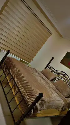 a bed in a room with a window with a blind at شقه مفروشه للإيجار مكونه من 4 غرف في عمان in Amman