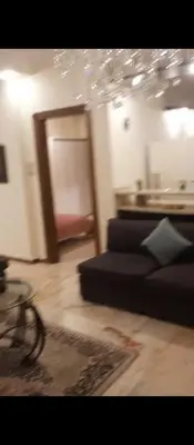 a living room with a black couch and a table at شقه مفروشه بالكامل في عمان شارع مكه ضاحيه الأمير راشد in Amman