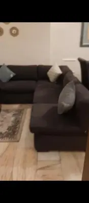 a black couch with pillows in a living room at شقه مفروشه بالكامل في عمان شارع مكه ضاحيه الأمير راشد in Amman