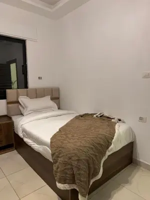 a bedroom with a bed with a blanket on it at RoofTOP SPORTCITY in Amman
