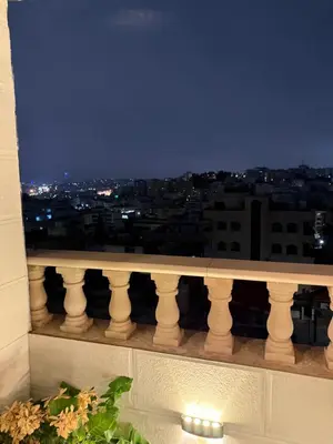 a view of a city at night from a balcony at RoofTOP SPORTCITY in Amman