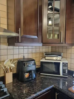 a kitchen counter with a toaster and a microwave at Elegant 2 bedrooms in 4th circle-Diplomatic Area in Amman