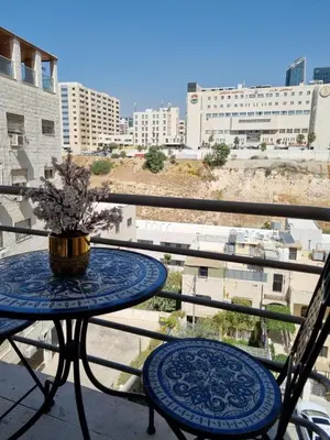 a table with a vase on top of a balcony at Elegant 2 bedrooms in 4th circle-Diplomatic Area in Amman