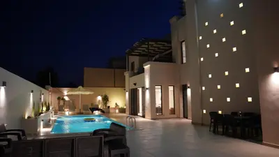 a patio with a swimming pool at night at RV Villas Deadsea in Sowayma