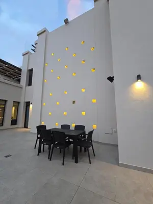 a black table and chairs in front of a wall at RV Villas Deadsea in Sowayma