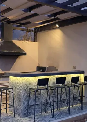 a bar with stools in a room with a stove at RV Villas Deadsea in Sowayma