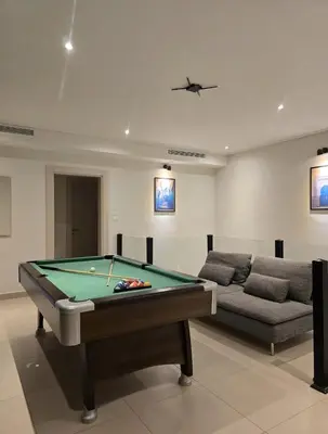 a living room with a pool table and a couch at RV Villas Deadsea in Sowayma