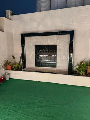 a brick fireplace with a green floor in a building at Rooftop sport city in Amman