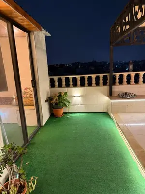 a balcony with a green lawn on a house at Rooftop sport city in Amman