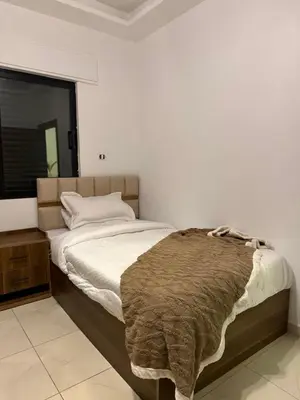 a bedroom with a bed with a brown blanket on it at Rooftop sport city in Amman