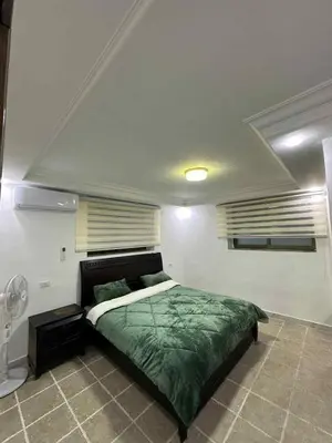 a bedroom with a bed with a green comforter at Cozy Studio 1 Central Amman Near Rainbow Street in Amman