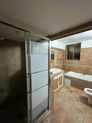 a bathroom with a shower and a tub and a toilet at Cozy Studio 1 Central Amman Near Rainbow Street in Amman