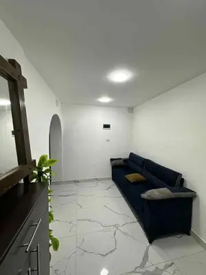 a living room with a blue couch in a room at Cozy Studio 1 Central Amman Near Rainbow Street in Amman