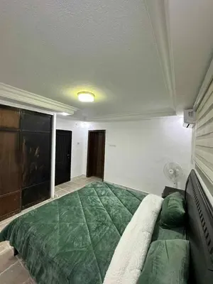 a bedroom with a large green bed in a room at Cozy Studio 1 Central Amman Near Rainbow Street in Amman
