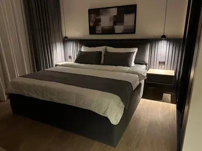 a bedroom with a large bed with a black headboard at Cozy Modern Apartment Damac Abdali in Amman