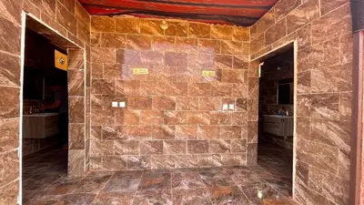a bathroom with a stone wall with two entrances at Wadi Rum Bedoun in Wadi Rum