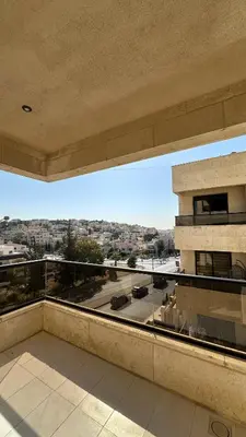 a balcony with a view of a parking lot at Modern 2BR Apartment in Deir Ghbar in Amman