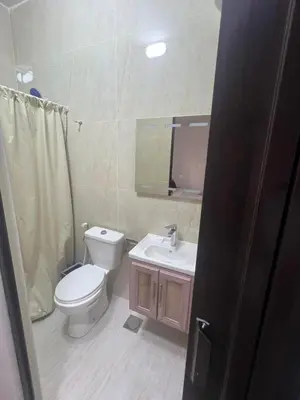 a bathroom with a toilet and a sink and a mirror at Cozy Studio Apartment in Amman