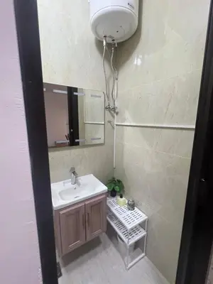 a bathroom with a sink and a mirror at Cozy Studio Apartment in Amman
