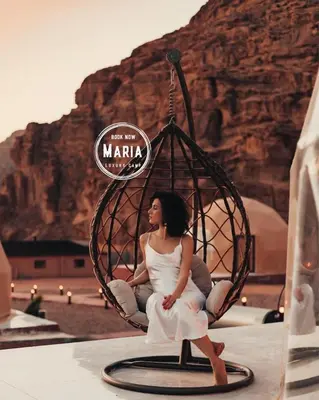 a woman sitting in a swing in the desert at MARIA LUXURY CAMp&BUBBLES ROOM in Wadi Rum