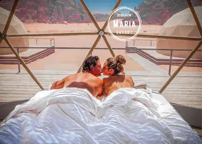 a man and a woman laying in bed at MARIA LUXURY CAMp&BUBBLES ROOM in Wadi Rum