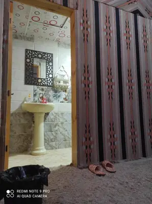 a bathroom with a sink and a mirror and shoes at Oasis of Wonders Camp in Wadi Rum
