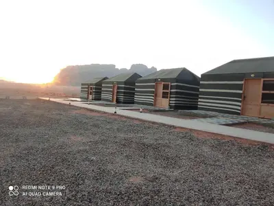 a row of houses in the middle of a field at Oasis of Wonders Camp in Wadi Rum