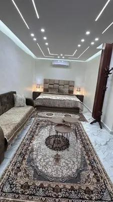 a bedroom with a bed and a couch and a rug at Nadina Bedouin home in Petra