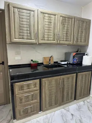 a kitchen with wooden cabinets and a sink at Nadina Bedouin home in Petra