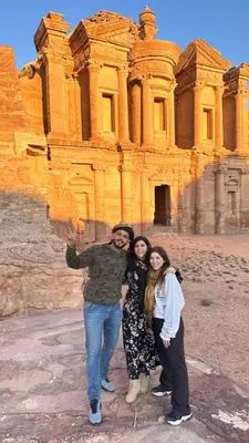 three people standing in front of a building at Nadina Bedouin home in Petra